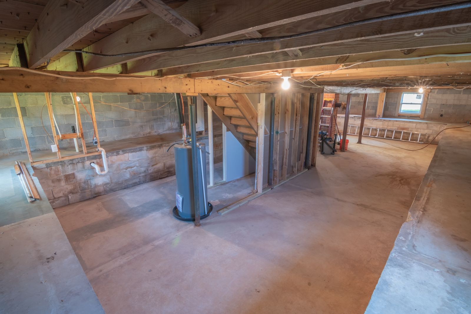 Unfinished basement with exposed beams and pipework
