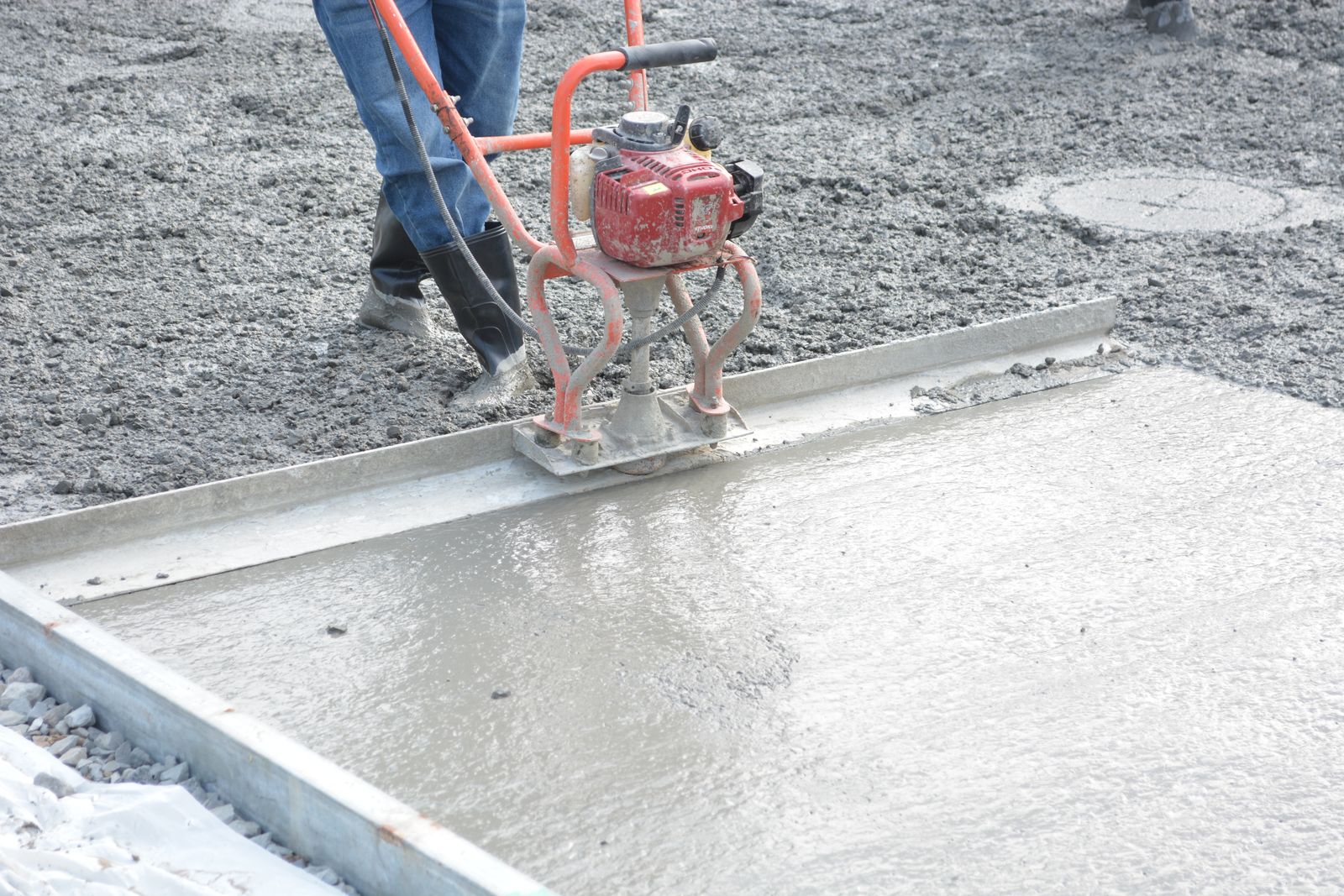 Freshly poured concrete slab being power-troweled